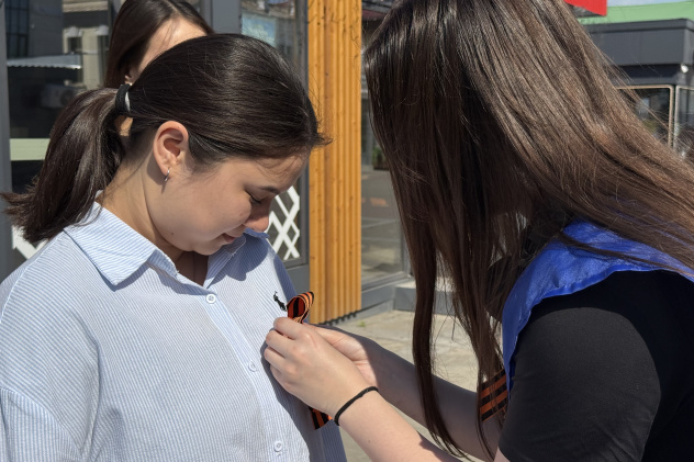 Активистка прикалывает георгиевскую ленточку жительнице города Активистка прикалывает георгиевскую ленточку жительнице города