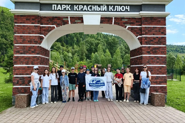Группа активистов с флагом молодёжного клуба у арки парка «Красный Ключ»