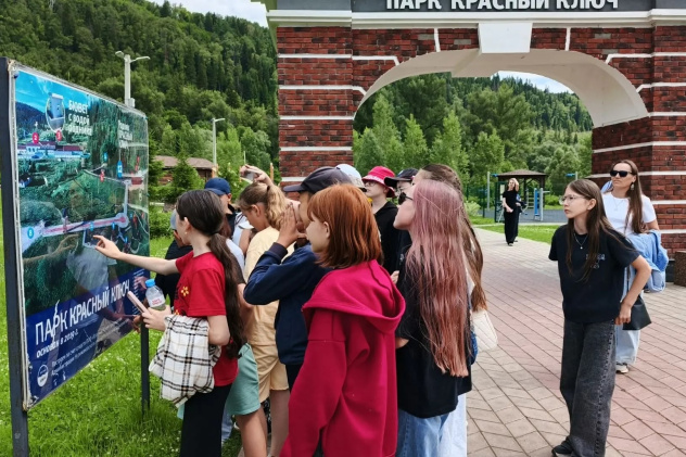 Участники экскурсии изучают карту парка «Красный Ключ» у главного входа