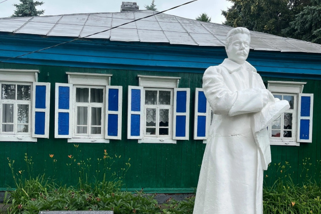 Памятник В.И. Чапаеву на фоне старинного дома с синими ставнями Памятник В.И. Чапаеву на фоне старинного дома с синими ставнями
