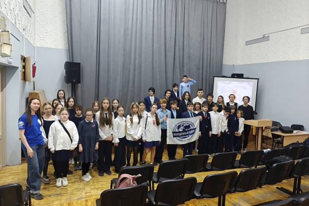Участники патриотического квиза с флагом Молодёжного клуба РГО «Земля и мы»