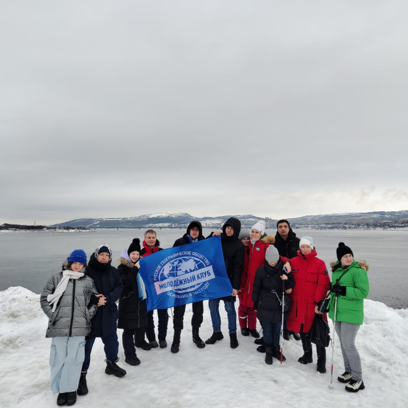Группа незрячих путешественников и юных волонтёров на берегу Кольского залива в Коле