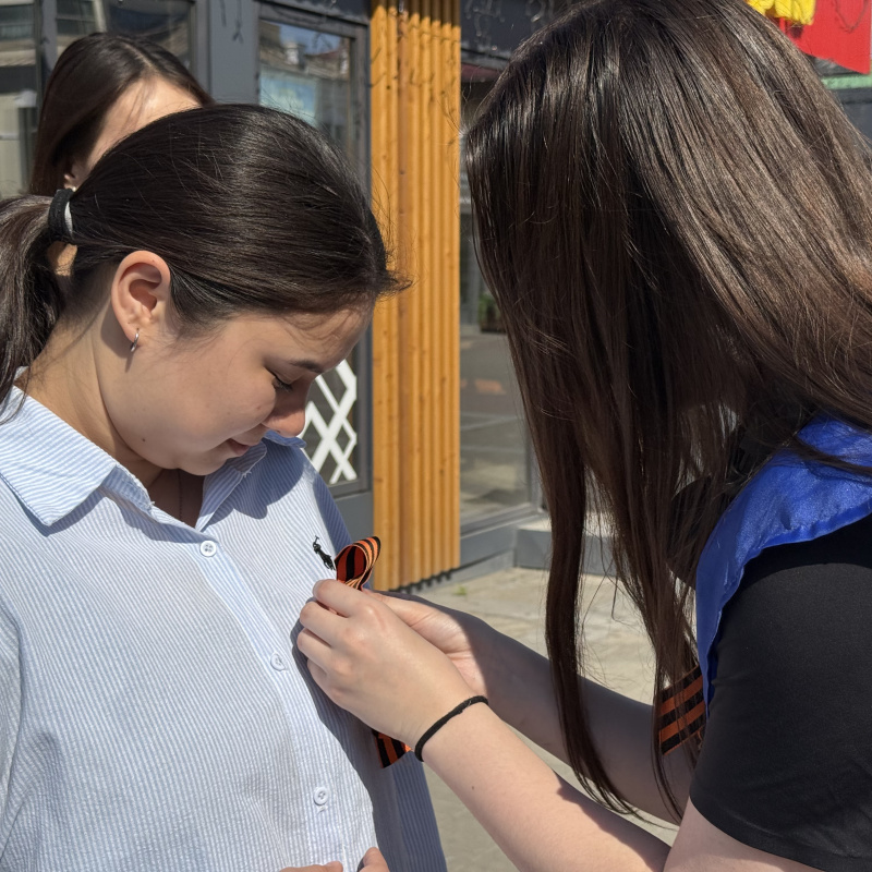 Активистка прикалывает георгиевскую ленточку жительнице города Активистка прикалывает георгиевскую ленточку жительнице города