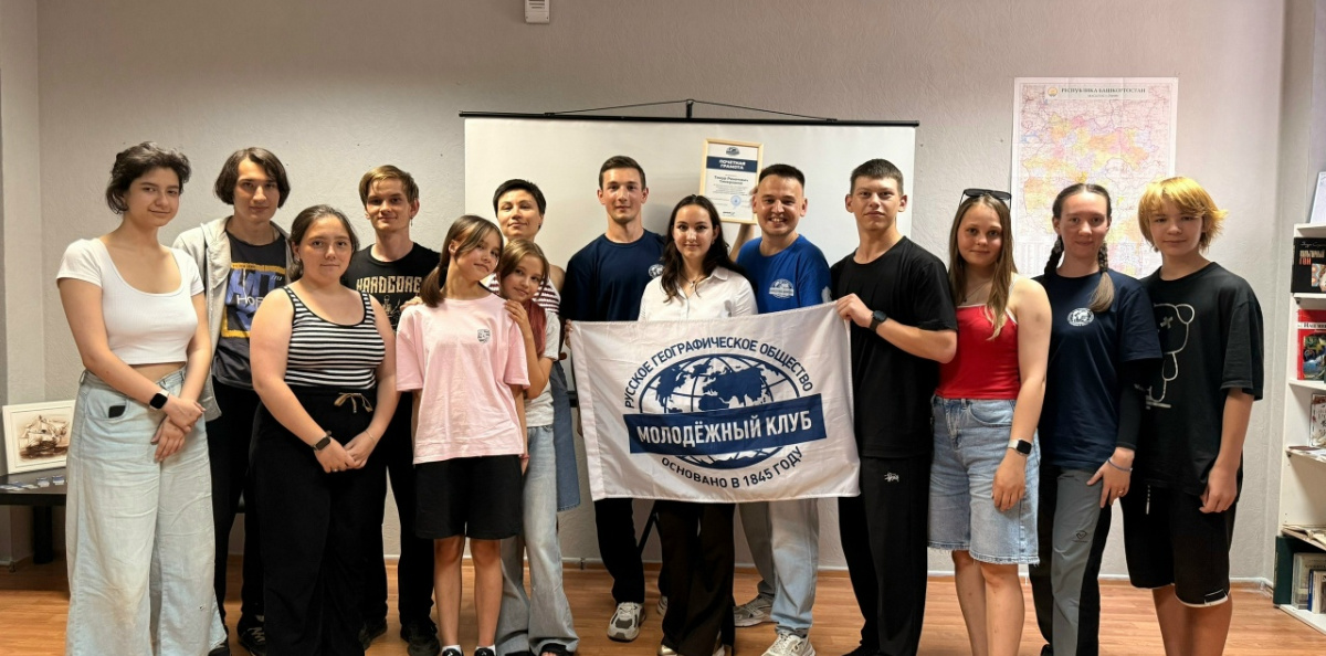 Общая фотография участников встречи с почётной грамотой и флагом РГО