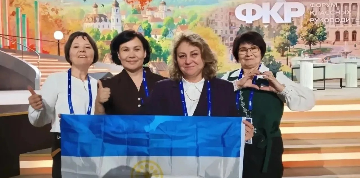 Халида Рахимкулова (в центре) с коллегами на фоне бренд-волла Форума классных руководителей