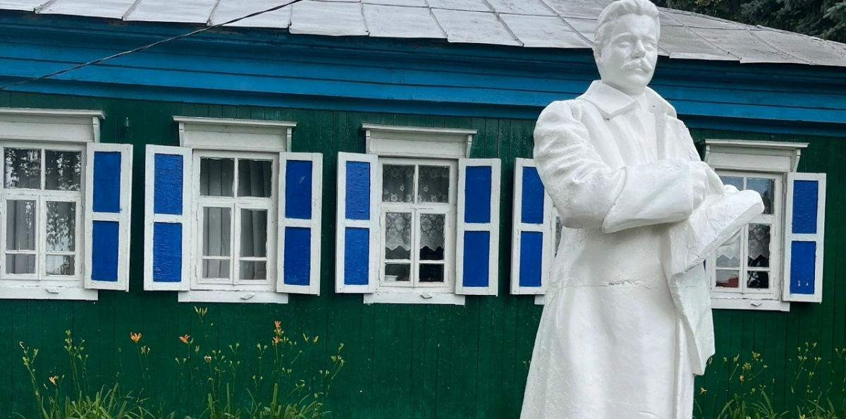 Памятник В.И. Чапаеву на фоне старинного дома с синими ставнями