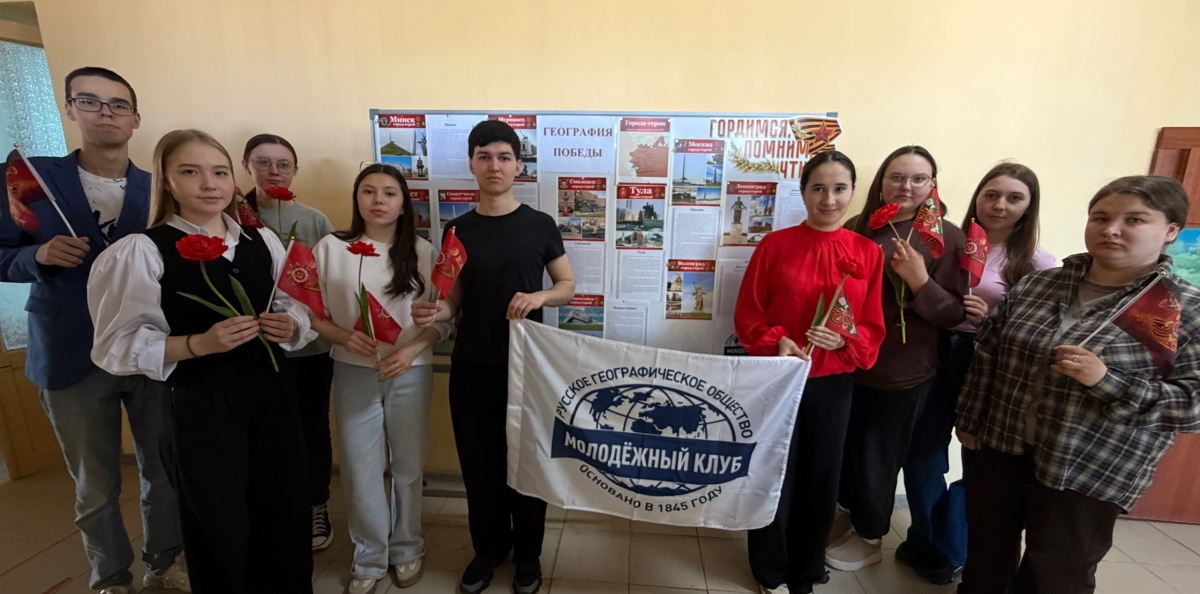 Активисты Молодёжного клуба РГО «Бирские меандры» у интерактивного стенда «География Победы» с флагом РГО