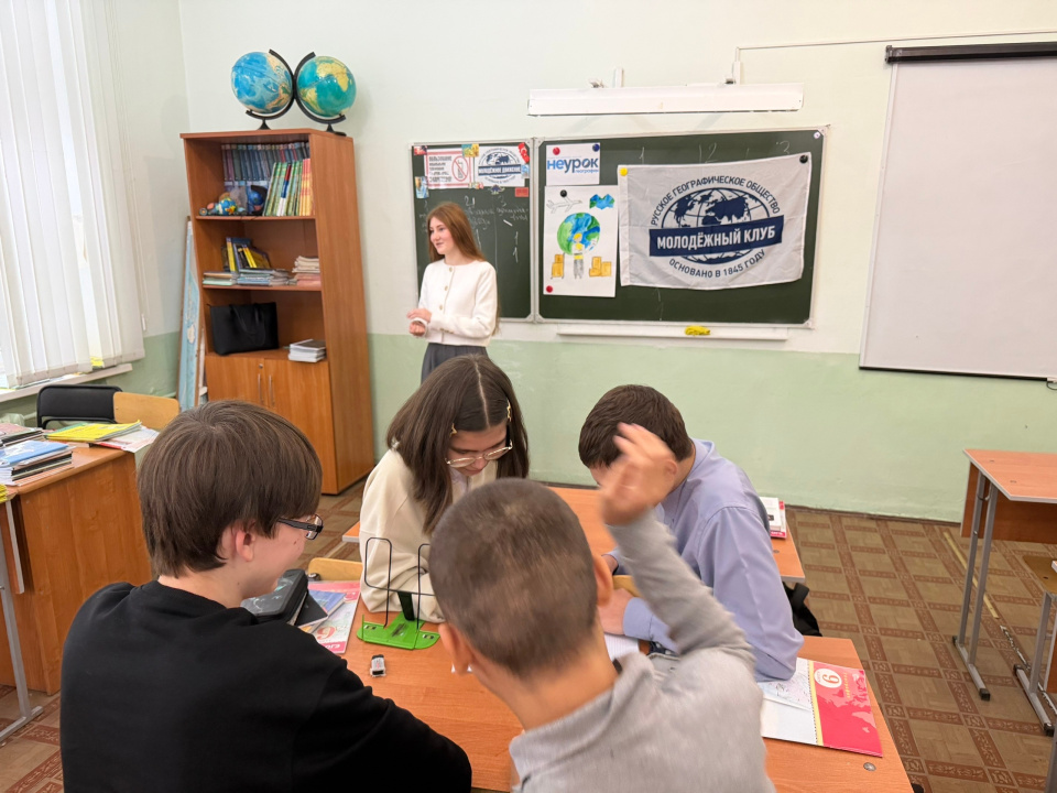 Ведущая игры у доски с флагом МК РГО