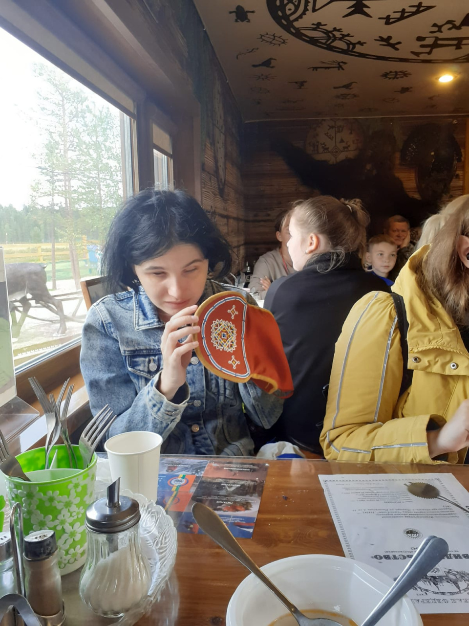 Незрячая Надежда Долматова рассматривает саамскую шапочку-шамшуру. Саамская деревня "Самь-Сыйт", 02.08.2024