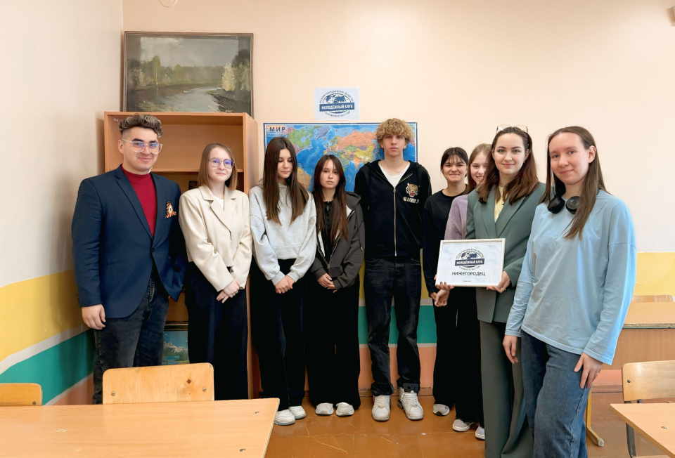 Участники и организаторы открытия Молодёжного клуба РГО «Нижегородец» на фоне карты мира и эмблемы клуба