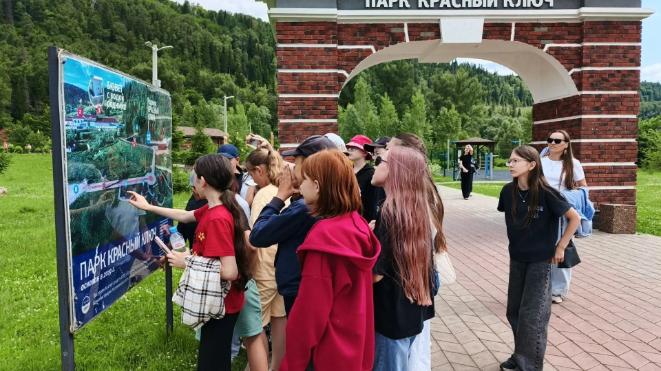 Участники экскурсии изучают карту парка «Красный Ключ» у главного входа