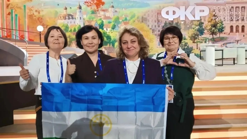 Халида Рахимкулова (в центре) с коллегами на фоне бренд-волла Форума классных руководителей
