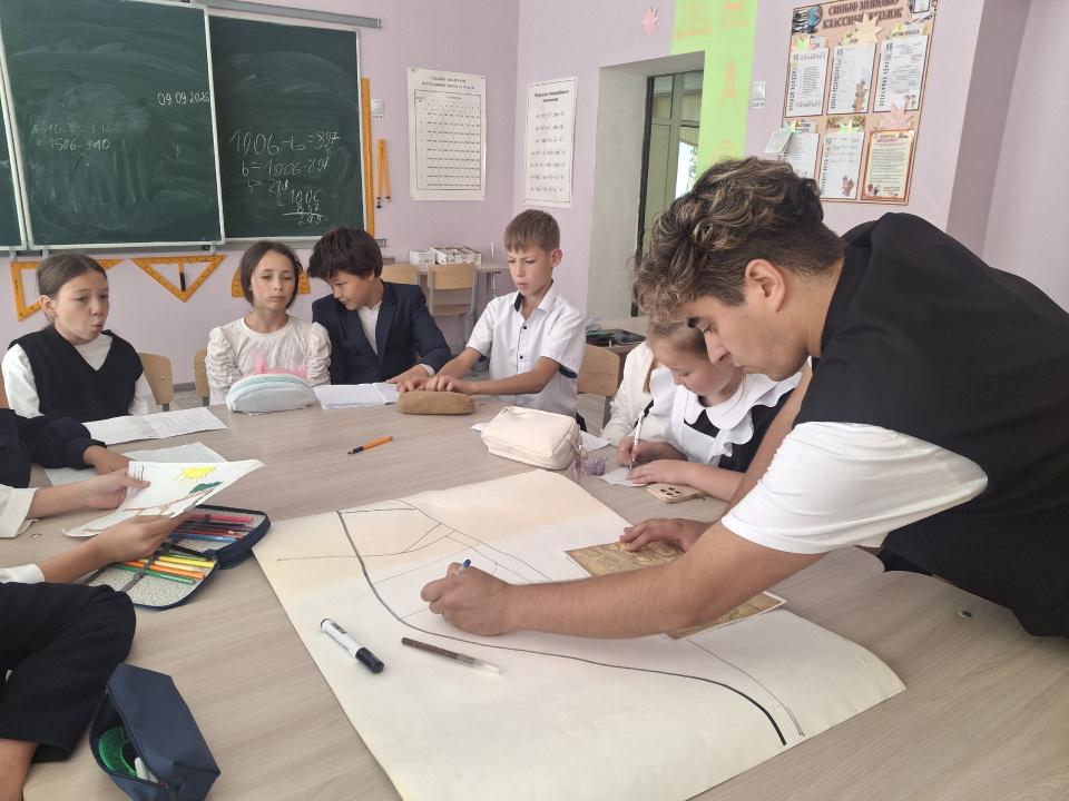 Наставник помогает ученикам с планом местности