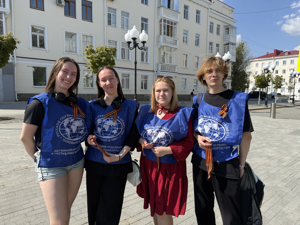 Волонтёры в фирменных жилетах Русского географического общества с георгиевскими ленточками