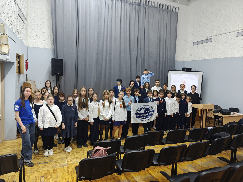 Участники патриотического квиза с флагом Молодёжного клуба РГО «Земля и мы»