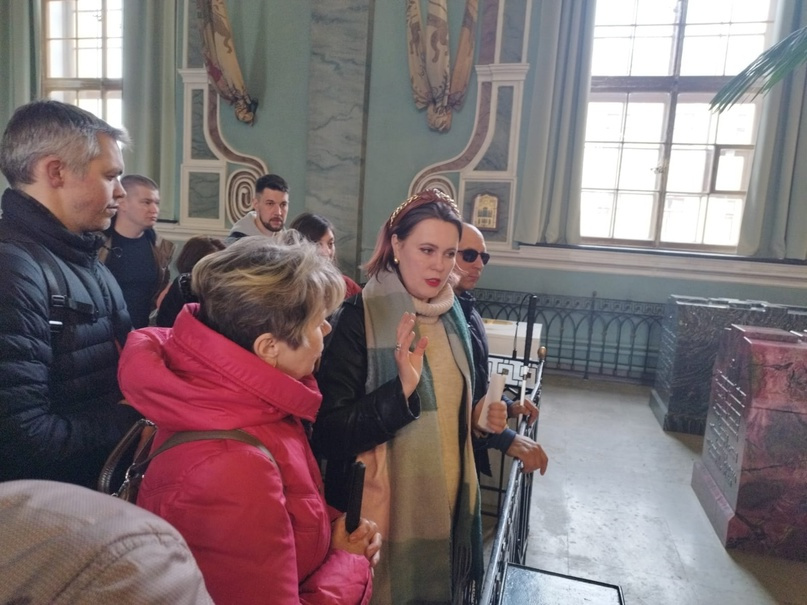 Экскурсовод Богдан Анна Андреевна делает тифлокомментарий для незрячих туристов, стоя перед мраморным саркофагом Александра III